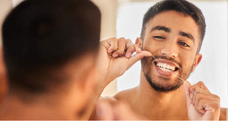 Mies käyttää hammaslankaa